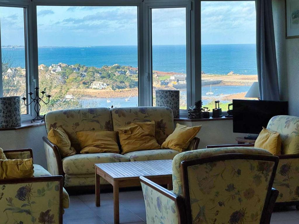 un salon avec un canapé et une vue sur l'océan dans l'établissement Ker Wind - panoramic sea view house Primel 8-10p, à Plougasnou