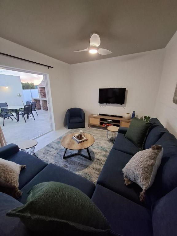 a living room with a blue couch and a table at Embrace This Planet Self-Catering Accommodation in Fisherhaven
