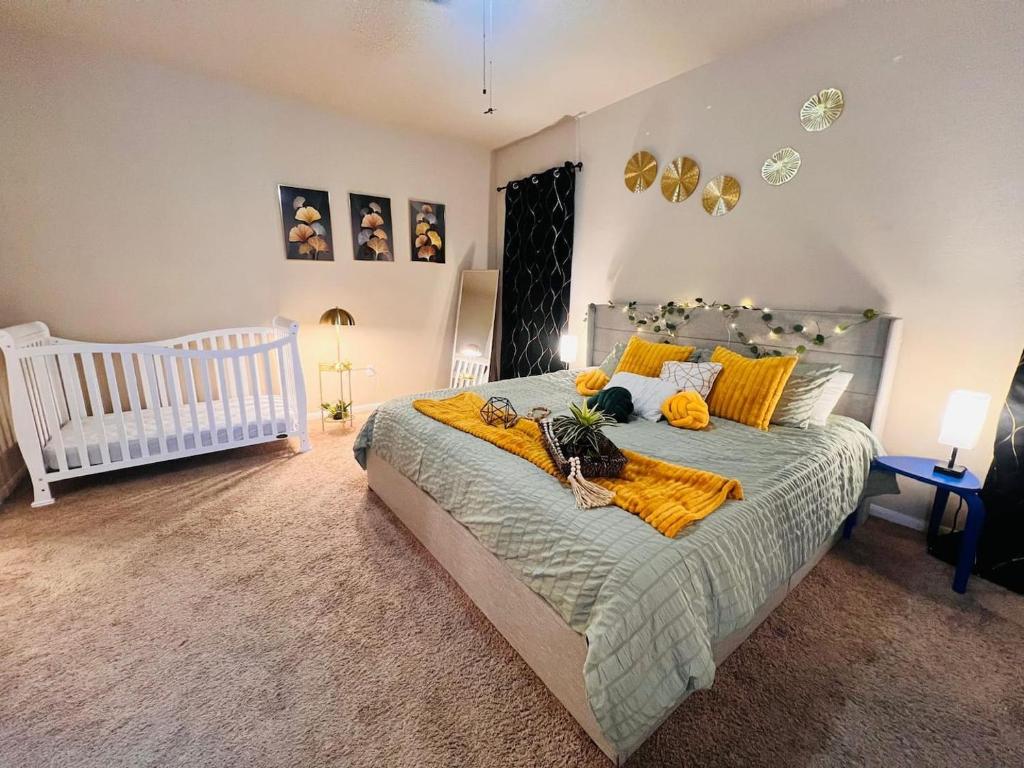 una camera da letto con un letto con coperte gialle e una culla di Pool Table, Foosball, King bed, Crib,Parking&Yard a Kyle