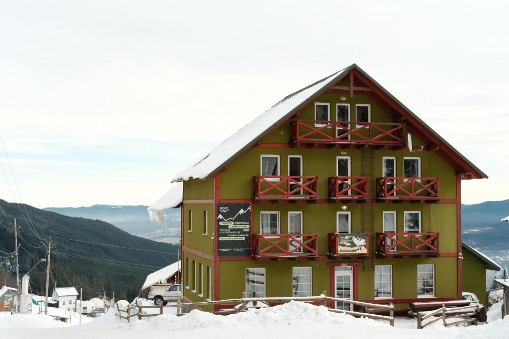 een groot gebouw met sneeuw op de grond bij Robert Hotel in Dragobrat