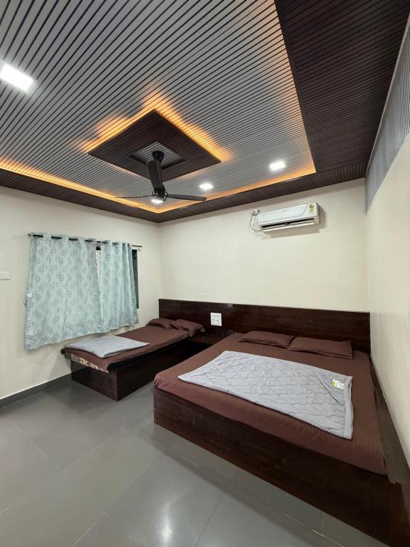 twee bedden in een kamer met een schuin plafond bij Patil residency in Matheran