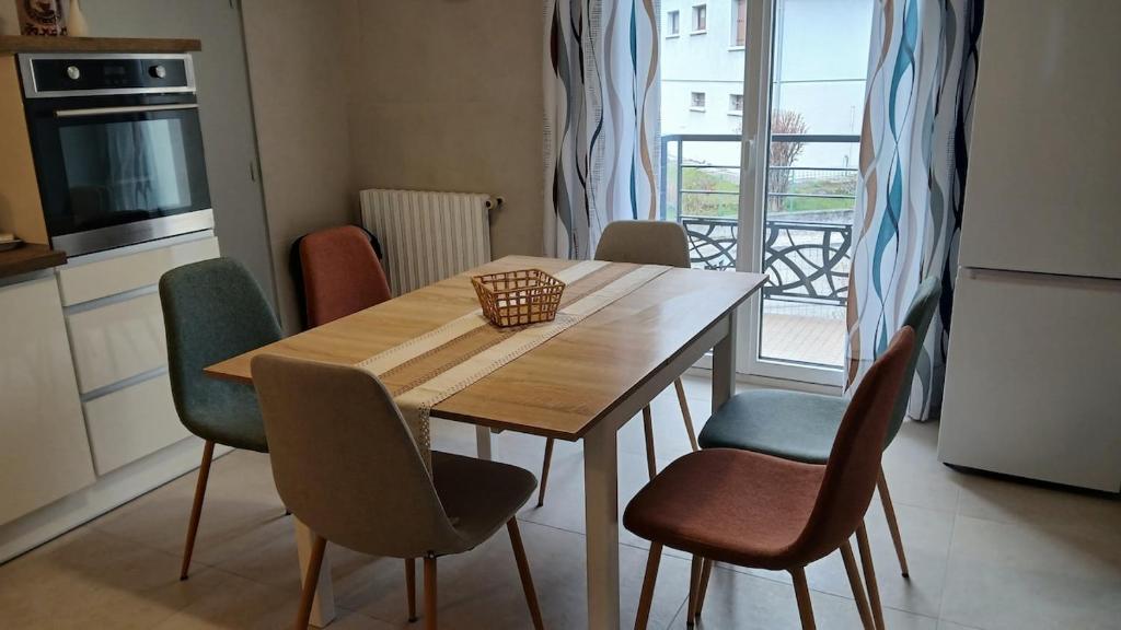 a kitchen with a wooden table and chairs in a kitchen at VILLARGONDRAN vélos en Maurienne garage motos in Villargondran