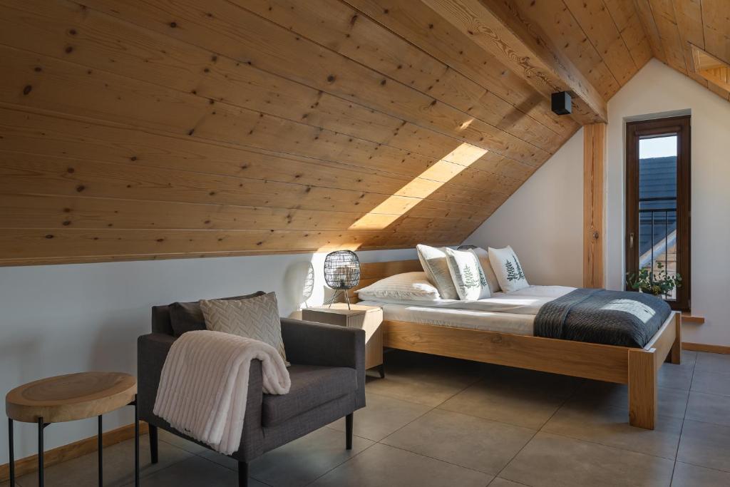 a bedroom with a bed and a chair at APARTAMENT No 1 MOUNTAIN VIEW Sauna Priv okolice Zakopane Czorsztyn Kluszkowce in Kluszkowce