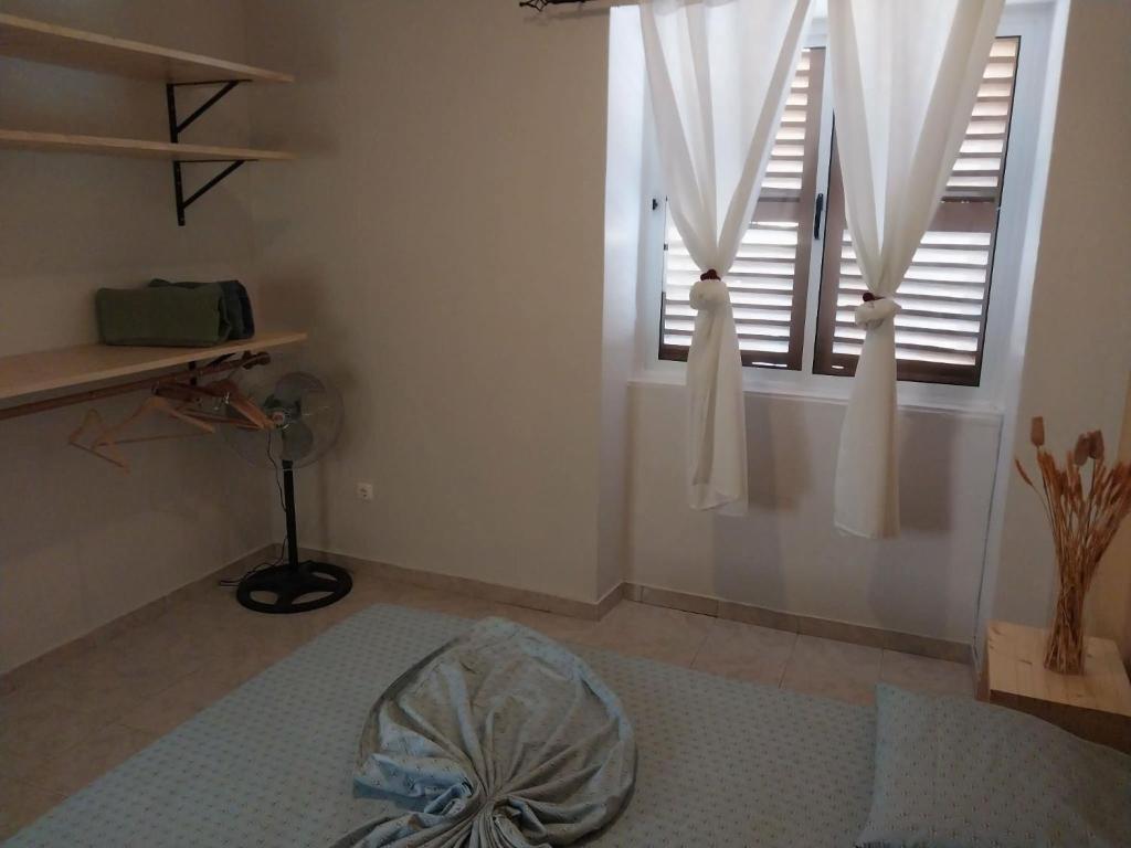 a room with a window with white curtains at Sol, Terra e Mar- No coração do Plateau in Praia