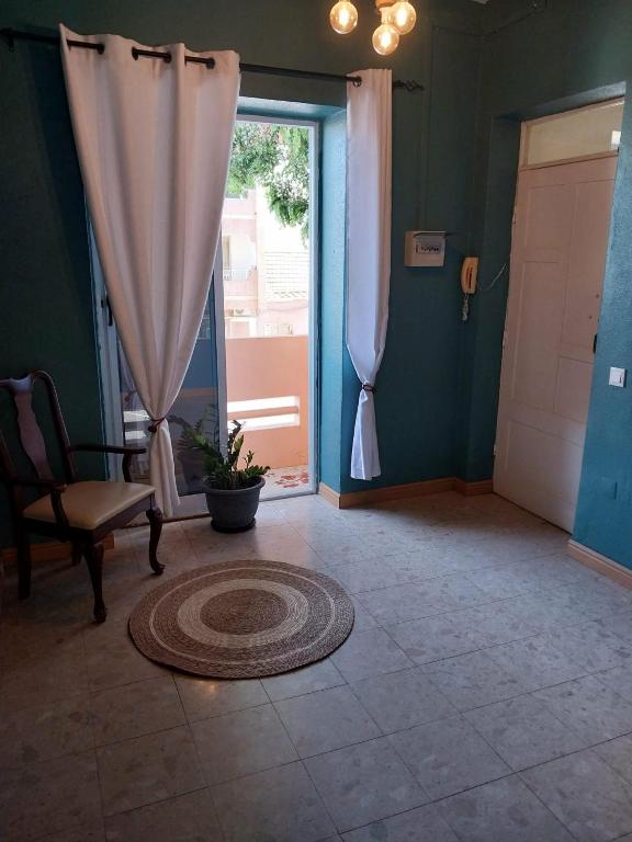 a room with a door and a chair and a window at Sol, Terra e Mar- No coração do Plateau in Praia