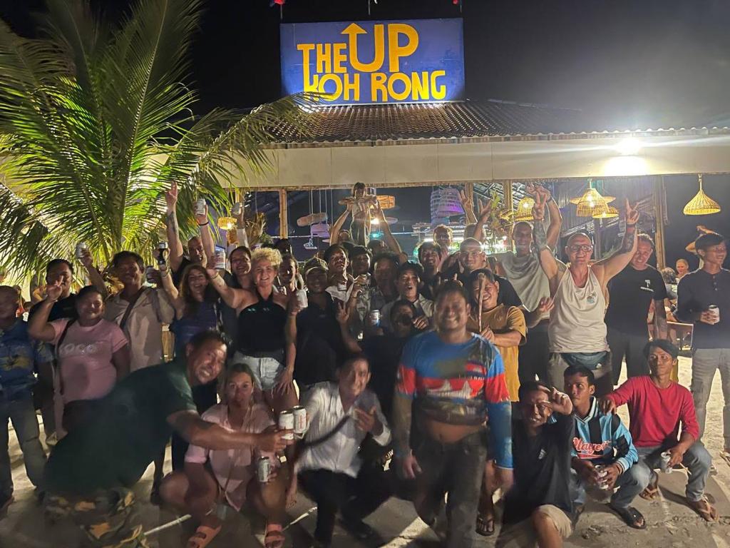 een groep mensen die poseren voor een foto voor een gebouw bij The Up Koh Rong in Kaôh Rŭng (3)