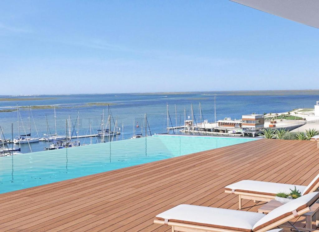 a swimming pool with a view of a marina at Prince Delmar Waterfront Olhao by Junto ao Mar in Olhão