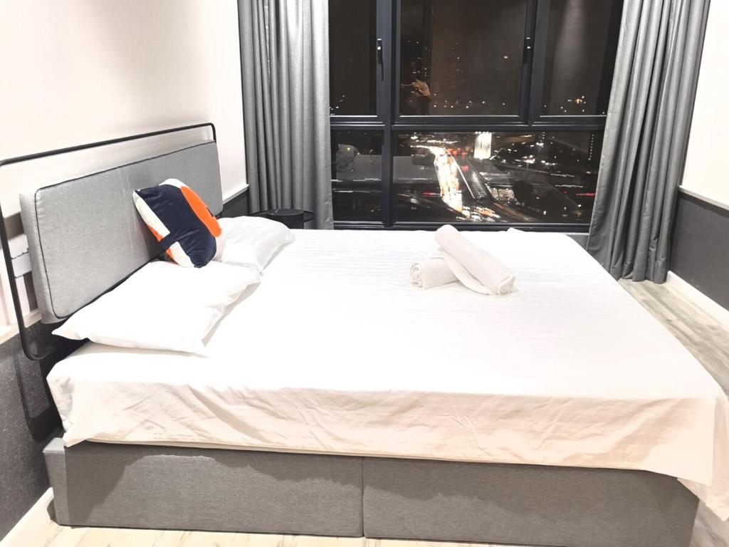a bedroom with a large white bed with a large window at Millerz Square block C in Kuala Lumpur