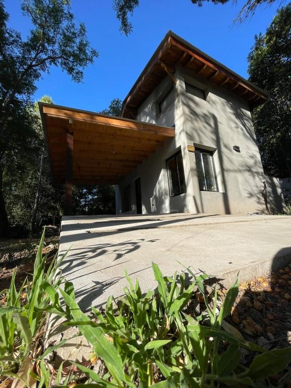 een stenen huis met een houten dak bij Wanna Hospedaje in Villa Ciudad Parque