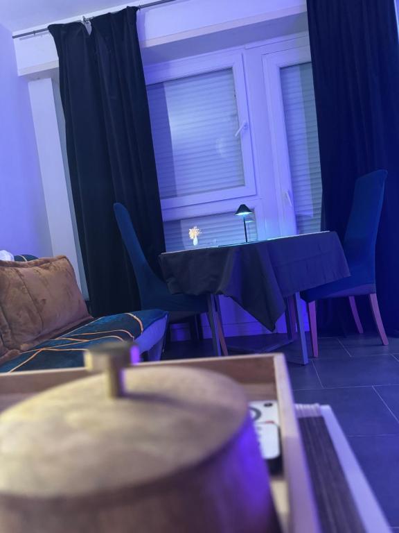 a living room with a black table and chairs at Studio Design à Mulhouse in Mulhouse