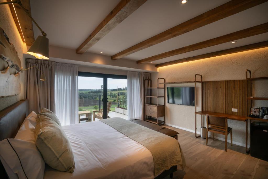 a bedroom with a large bed and a large window at Casa Pradera - Hotel Serrano in Sierra de los Padres