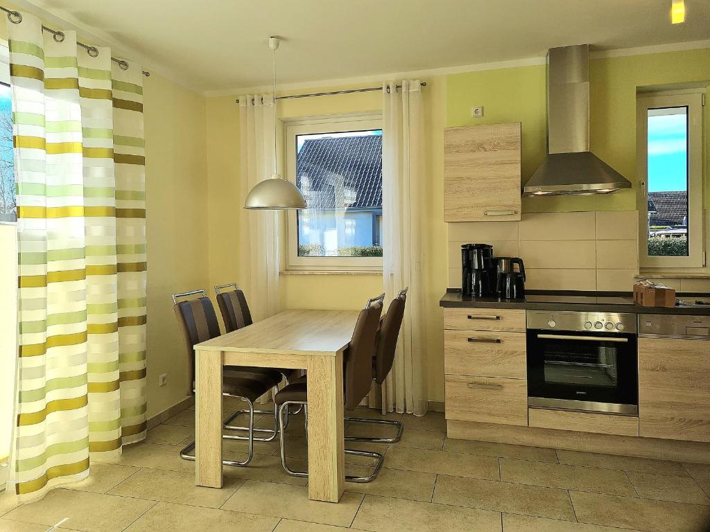 a kitchen with a wooden table and chairs at Ferienwohnung Seestern Suite im Haus Sonnensegler in Thiessow