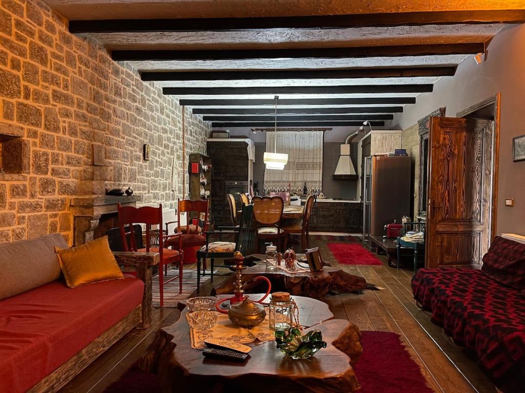 a living room with a red couch and a brick wall at Villa Naum in Voskopojë