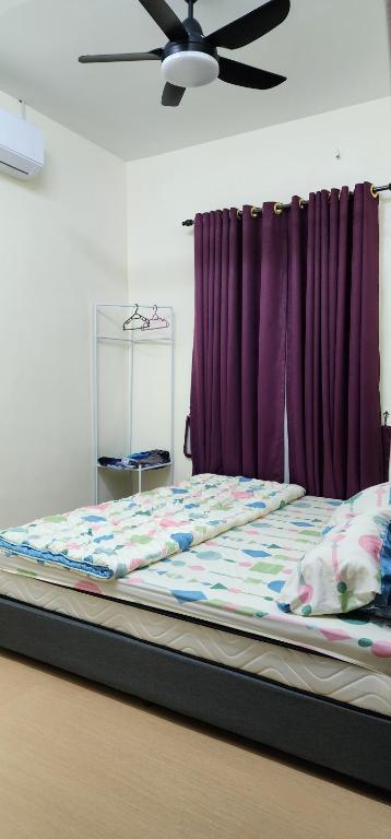 een bed in een kamer met een plafondventilator bij Homestay Ummi Baling in Baling