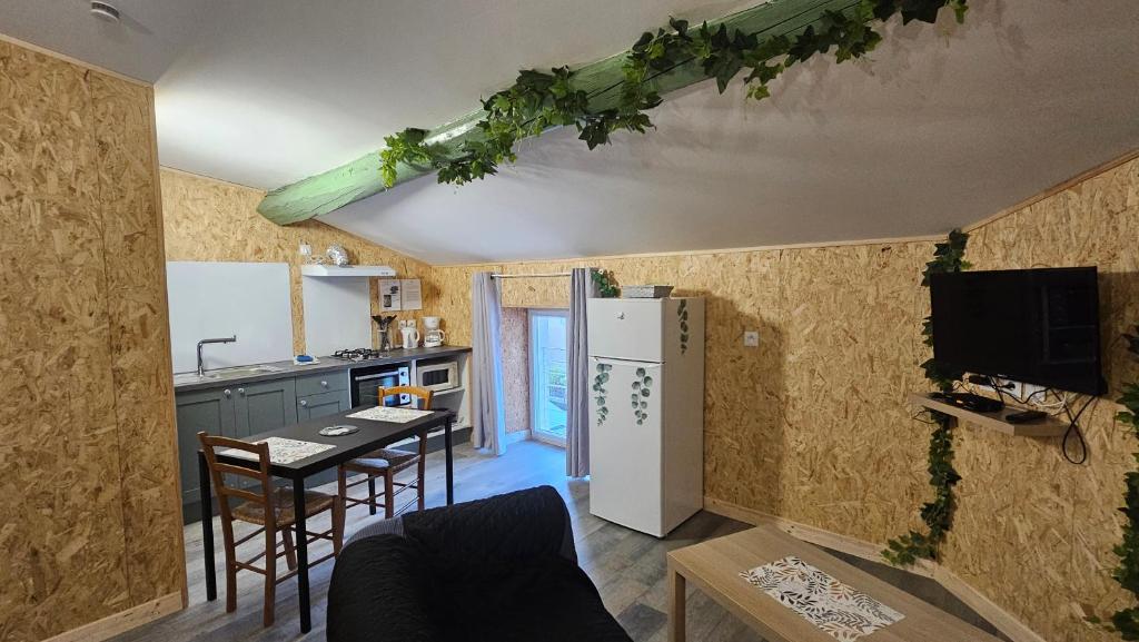 una cucina con frigorifero e tavolo con sedie di studio 4 a Fains-les-Sources