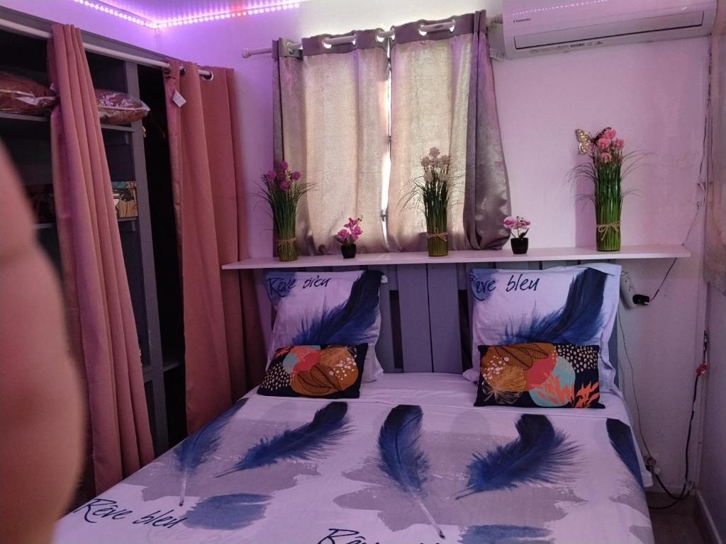 een slaapkamer met een bed met vogels erop bij Charmant appart in Fort-de-France