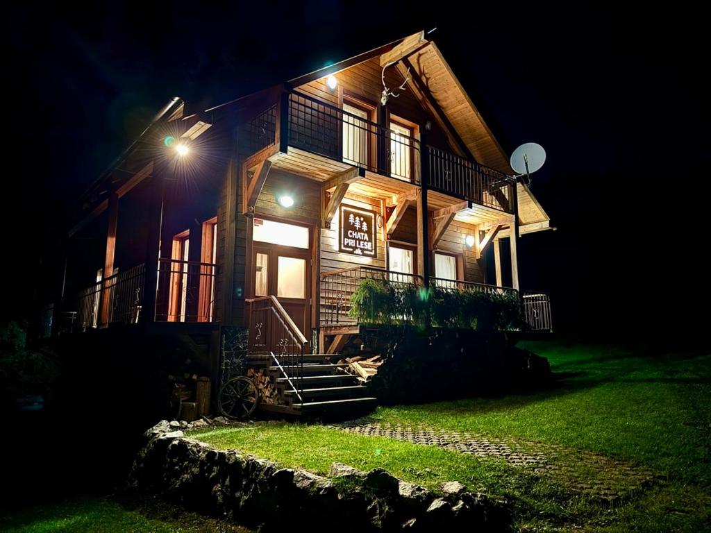 a house with lights on the side of it at night at Chata pri lese,Liptov in Bobrovec