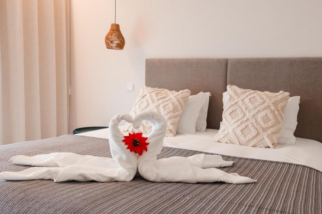a bed with a swan made out of towels at Conserveira 8 in Olhão