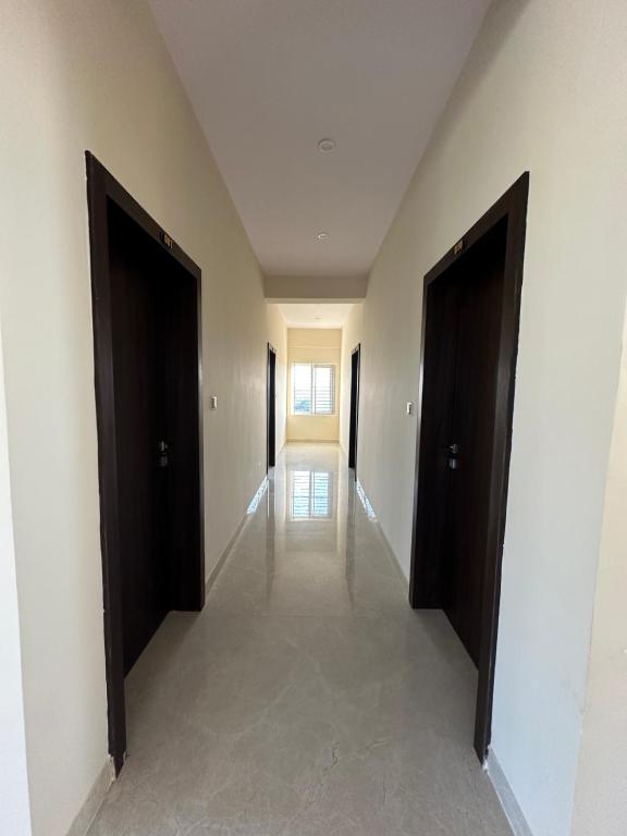 an empty hallway with two doors in a building at Nayana comforts in Nandigunda