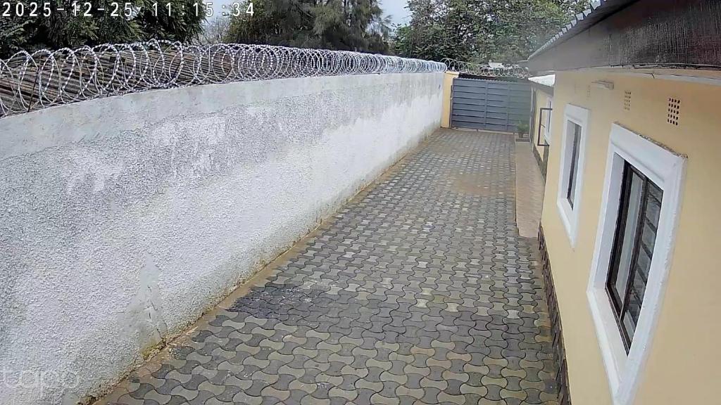 een stenen stoep naast een witte muur bij The Retreat in Lusaka