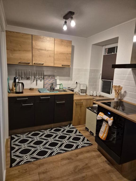 a kitchen with black cabinets and a black stove top oven at Haus an der Dorfteichstraße in Alt Krenzlin