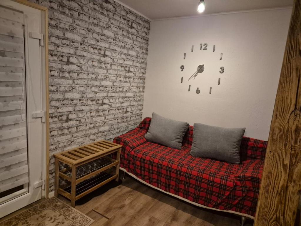 un salon avec un canapé et un mur de briques dans l'établissement Haus an der Dorfteichstraße, à Alt Krenzlin