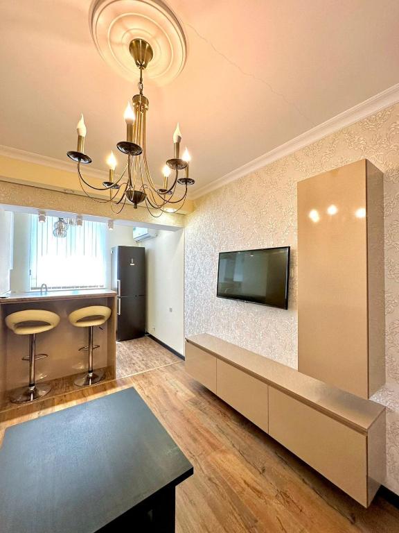 een woonkamer met een televisie en een tafel bij Nice Stay Near Center in Jerevan
