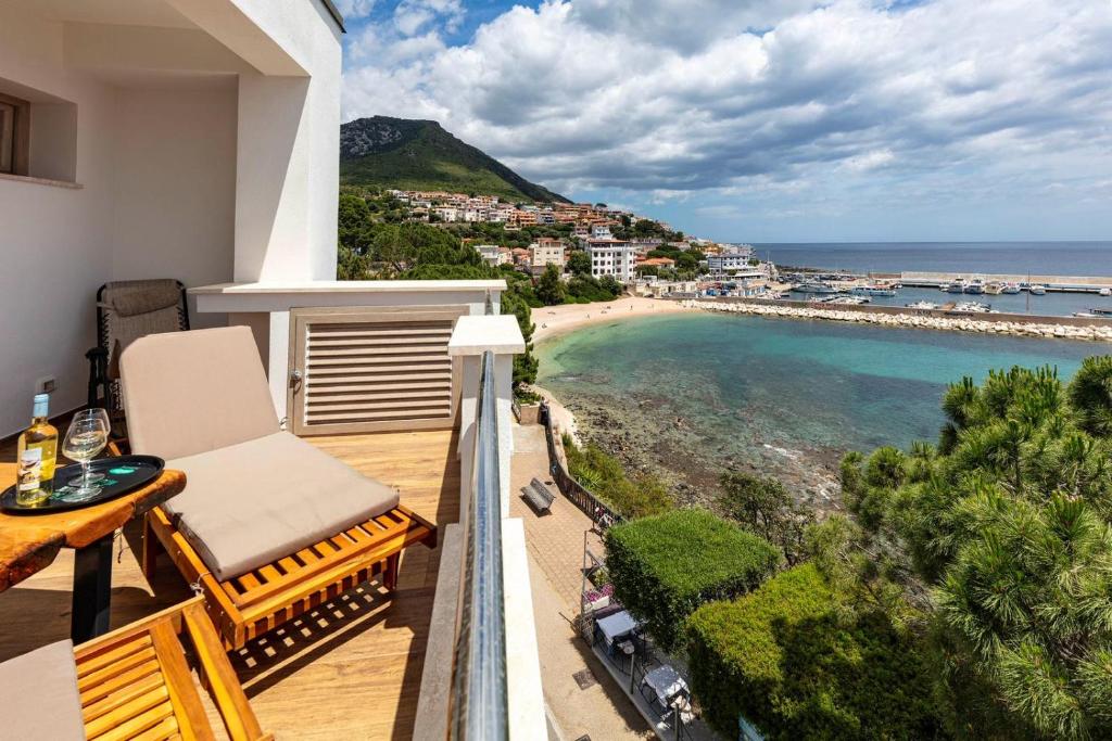 a balcony with a view of a beach and the ocean at Blue Bay rooms in Cala Gonone