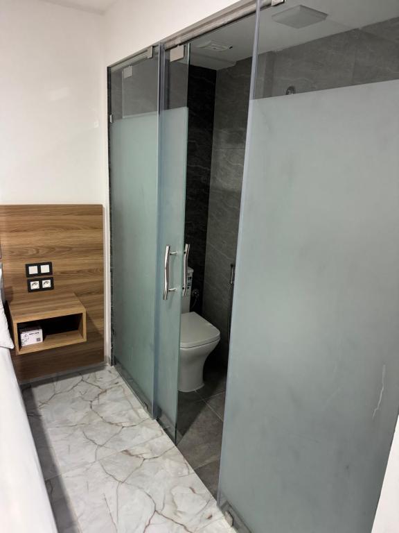 a bathroom with a glass shower with a toilet at Hôtel kairouan in Fez