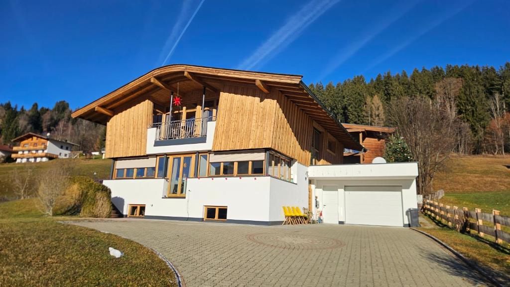 a house with a gambrel roof and a garage at Mountain Suite Brixen in Brixen im Thale