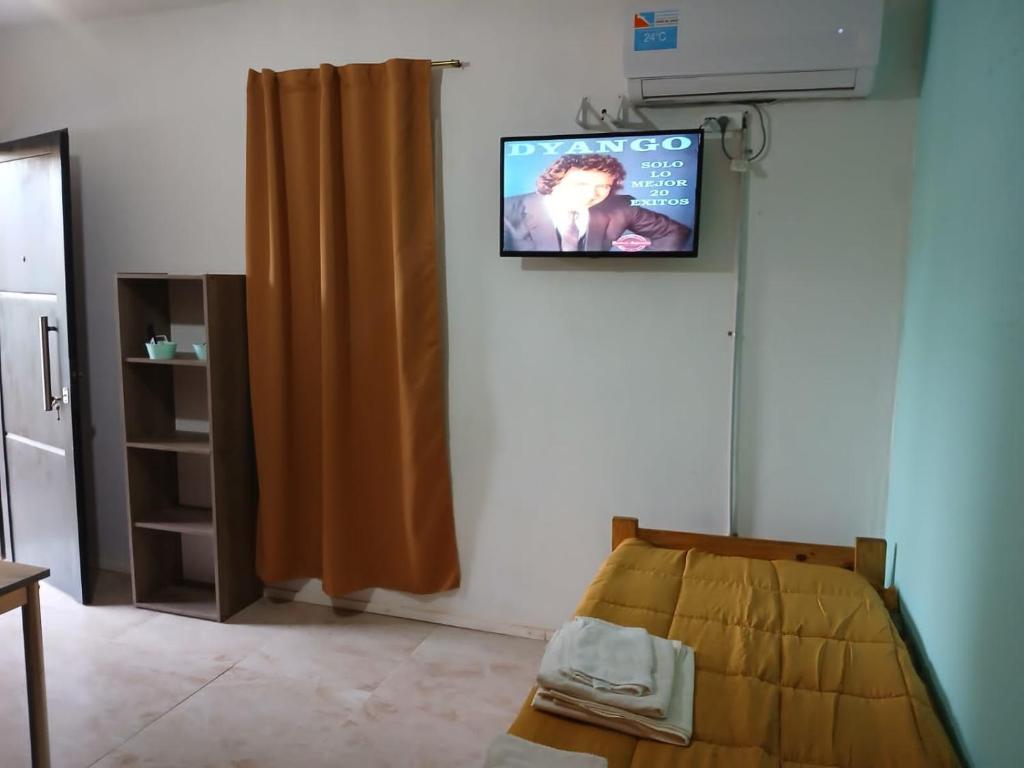 una camera con un letto e una televisione a parete di Departamentos de Campo Solar de las Chacras a Juana Koslay 