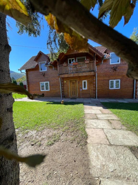 a log house with a porch at Cabana Lac in Sadu