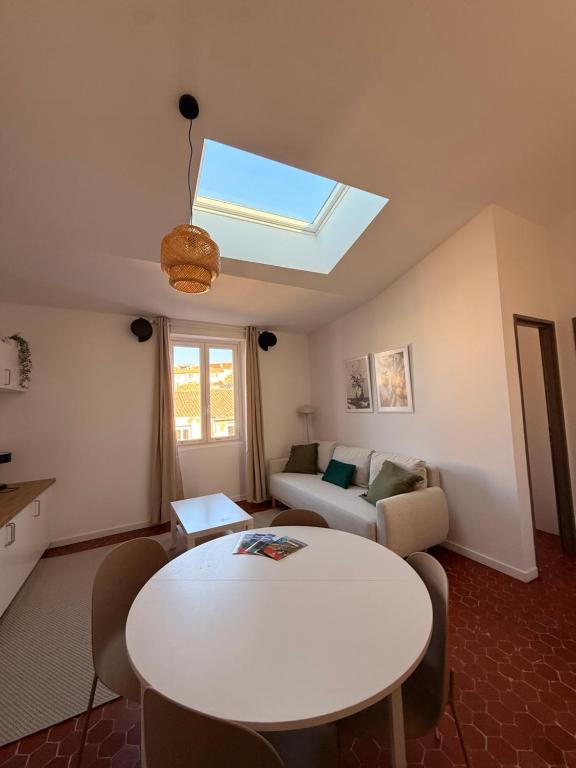 een woonkamer met een witte tafel en een dakraam bij Marius in Aubagne