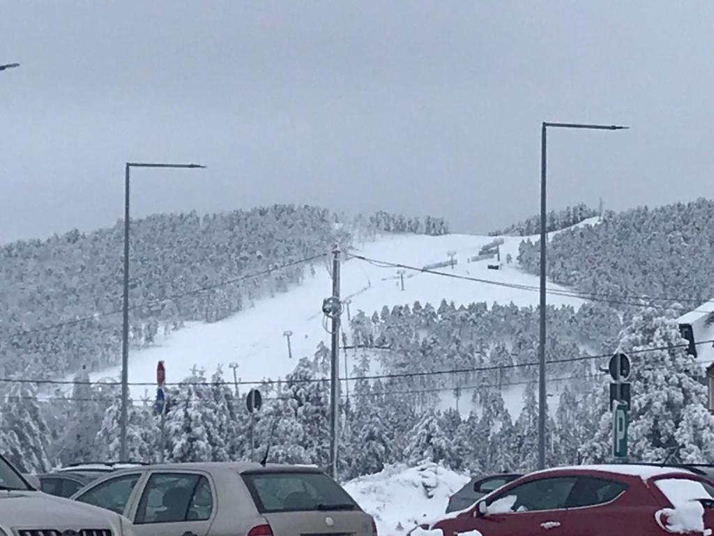 a snow covered hill with cars parked in a parking lot at Zeleni Mir in Divčibare
