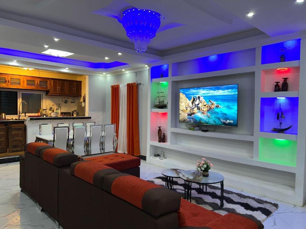 een woonkamer met een bank en een tv aan de muur bij Tranon'i Maria in Toamasina