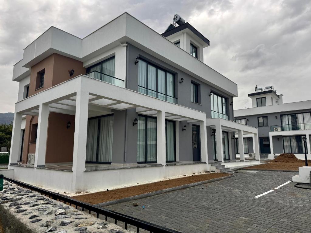 een groot wit gebouw met veel ramen bij Soğular Apartments 1 in Aglantzia