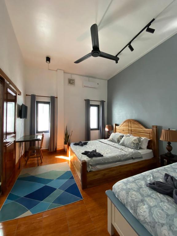 een slaapkamer met twee bedden en een plafondventilator bij Casa Primera in Luang Prabang