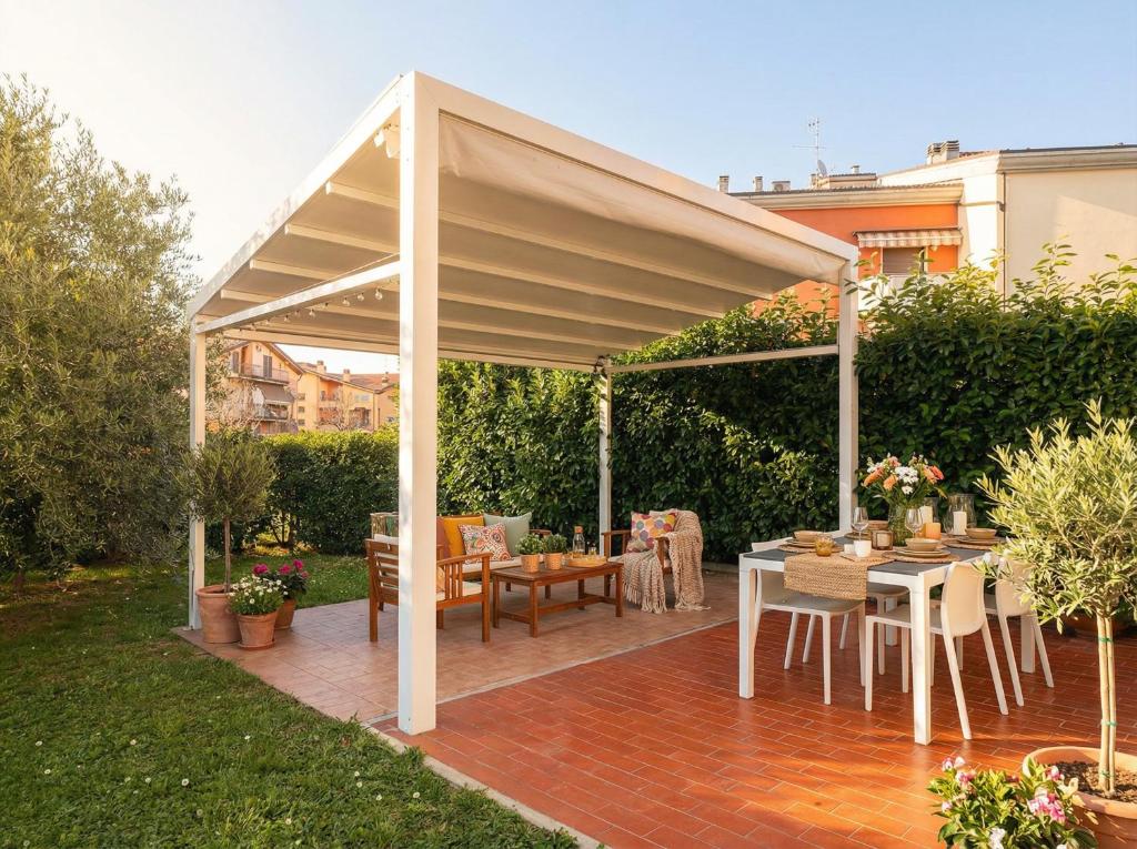 a pavilion with a table and chairs under it at Cleos Home con Giardino Privato e Free Parking in Arezzo