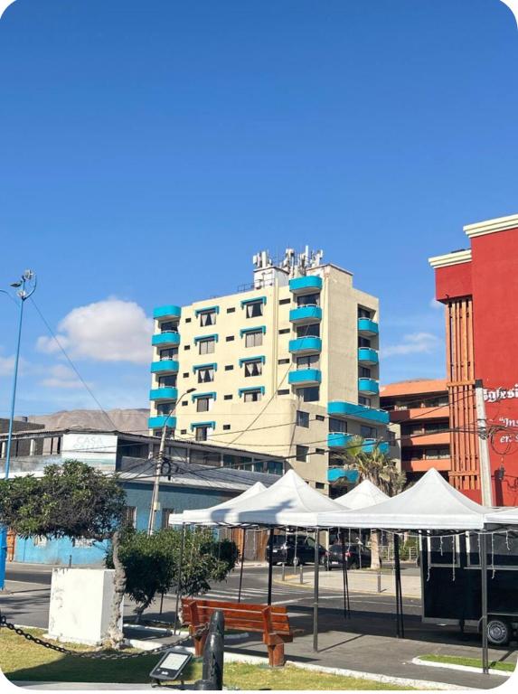 a large building with white umbrellas in a city at Hotel Capri in Iquique