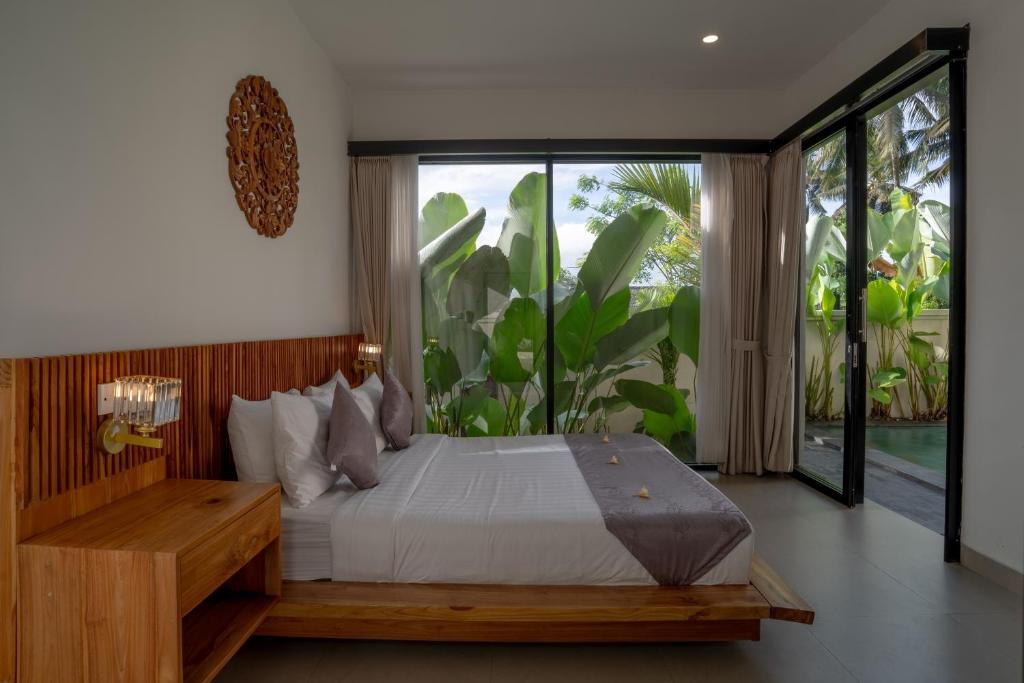 a bedroom with a bed and a large window at Waringin Villa Ubud in Ubud