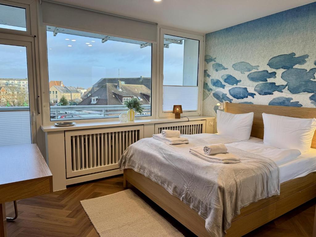 ein Schlafzimmer mit einem Bett und einem großen Fenster in der Unterkunft Boje in Westerland