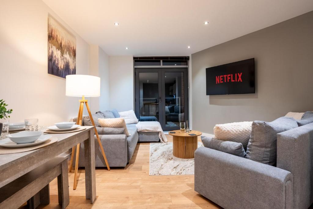 a living room with two couches and a table at Stylish 2 Bedroom APT with Balcony in Leeds