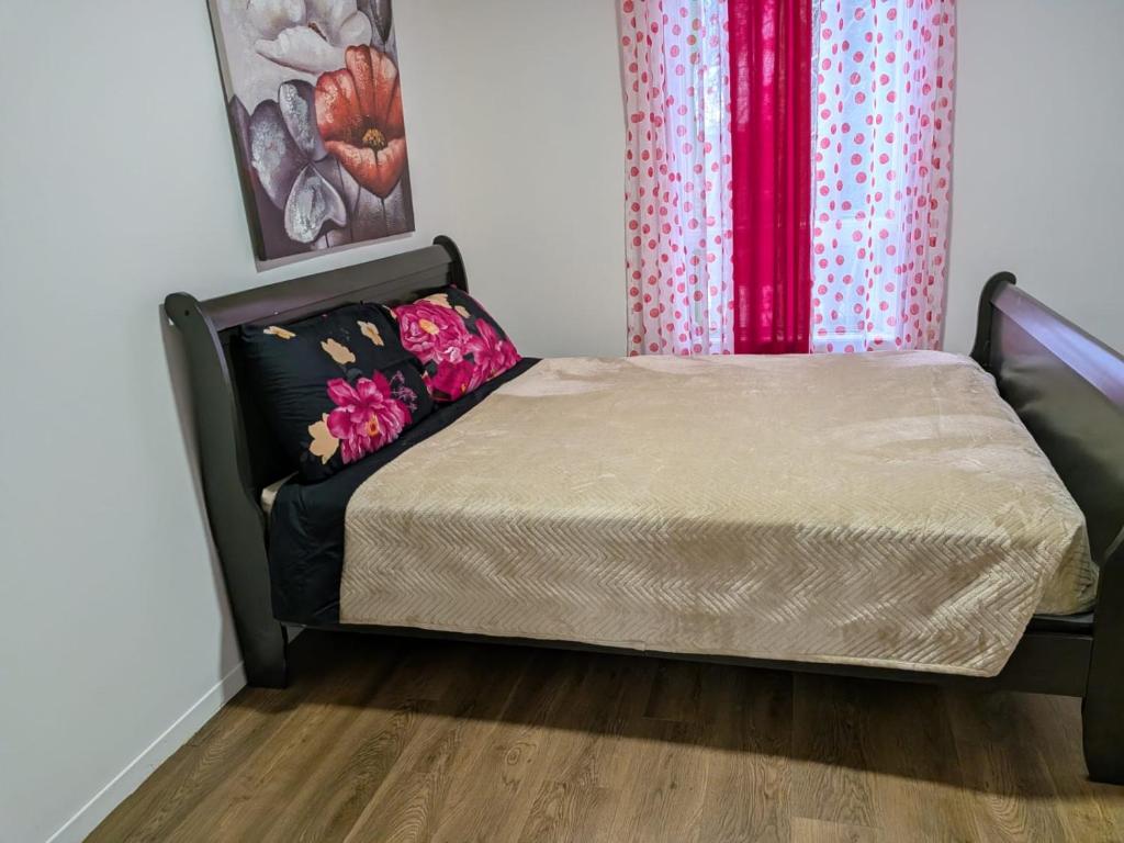 een slaapkamer met een bed en een gordijn bij Ici Chez Vous in Trois-Rivières