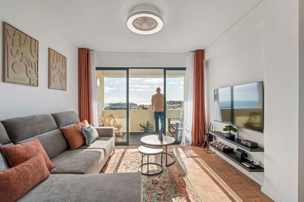 een man in een woonkamer die uit het raam kijkt bij View in Bicas