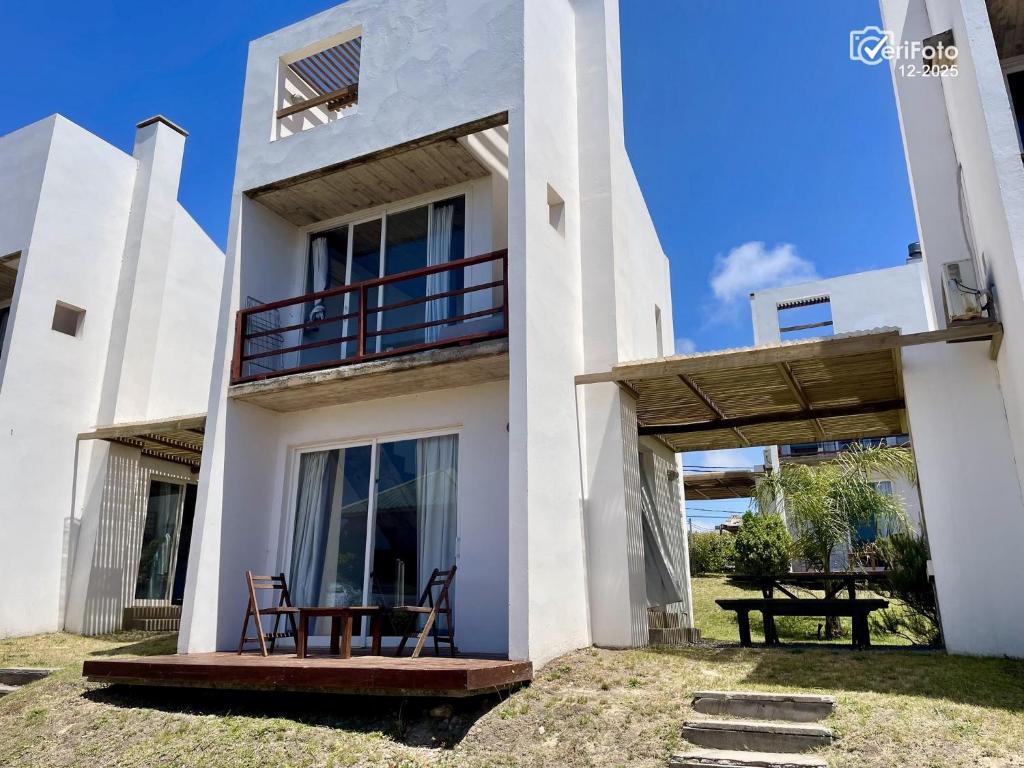a white house with two chairs on the balcony at Les Diablettes in Punta Del Diablo