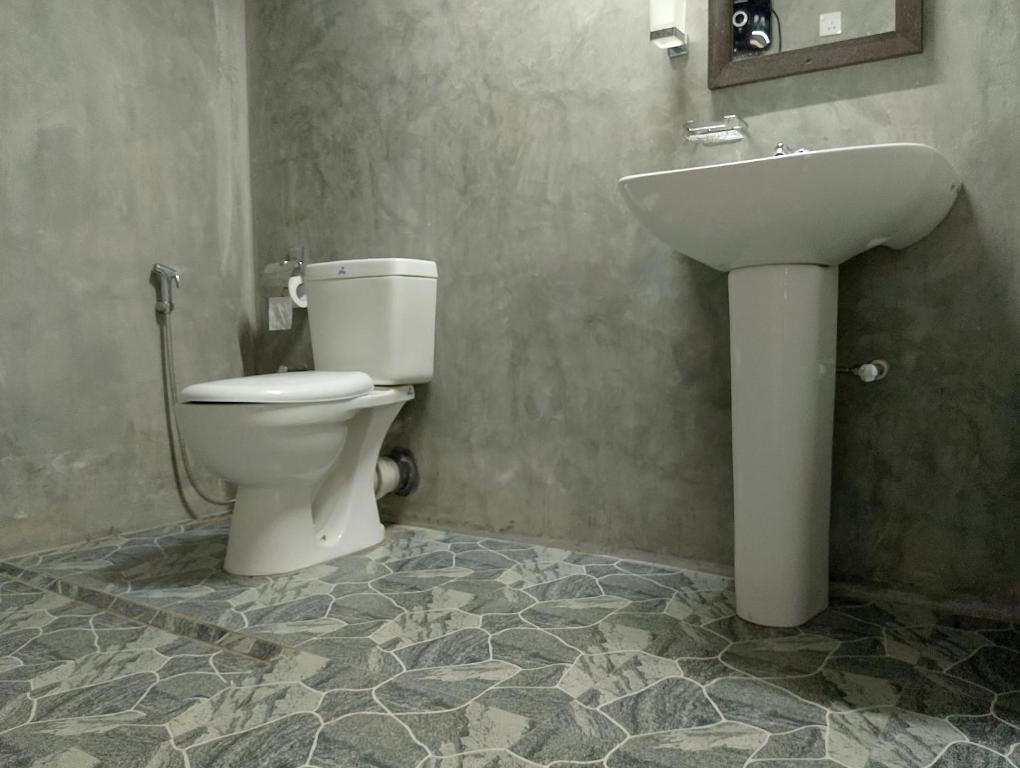 een badkamer met toilet en wastafel bij Rainforest cabin in Deniyaya
