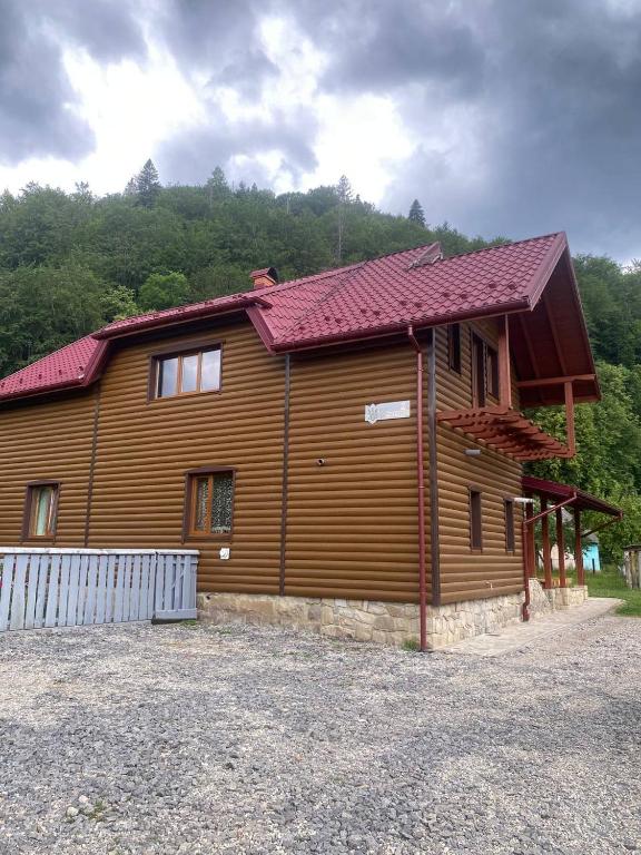 a large wooden house with a red roof at TaVa House 1 in Yaremche
