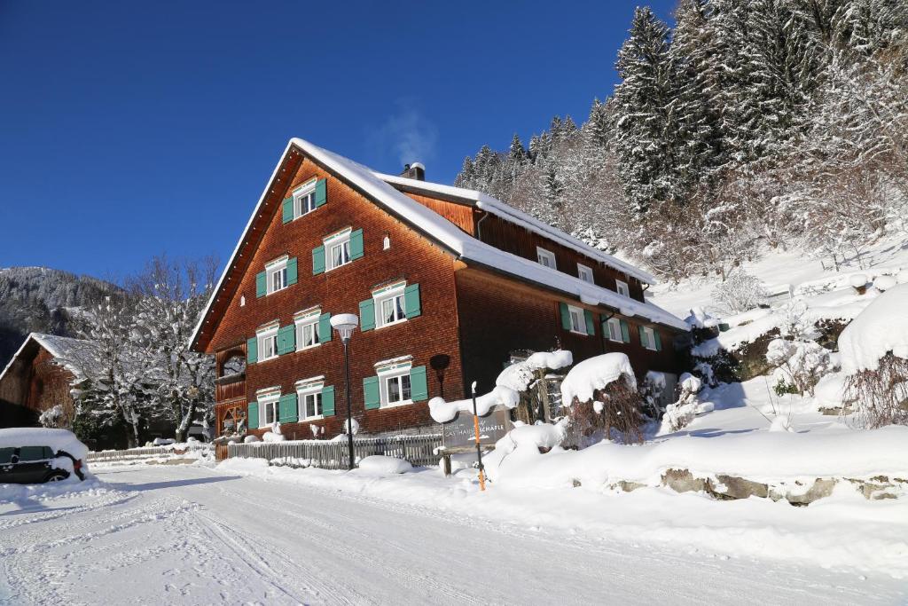 a large building in the snow with a road in front at Hotel Gasthaus Schäfle in Bürserberg