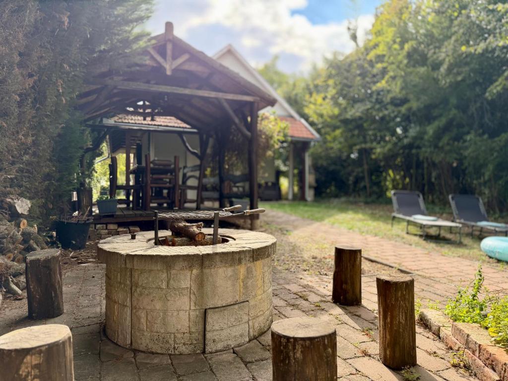 a fire pit in a yard with a pavilion at Csendzug Vendégház in Békésszentandrás