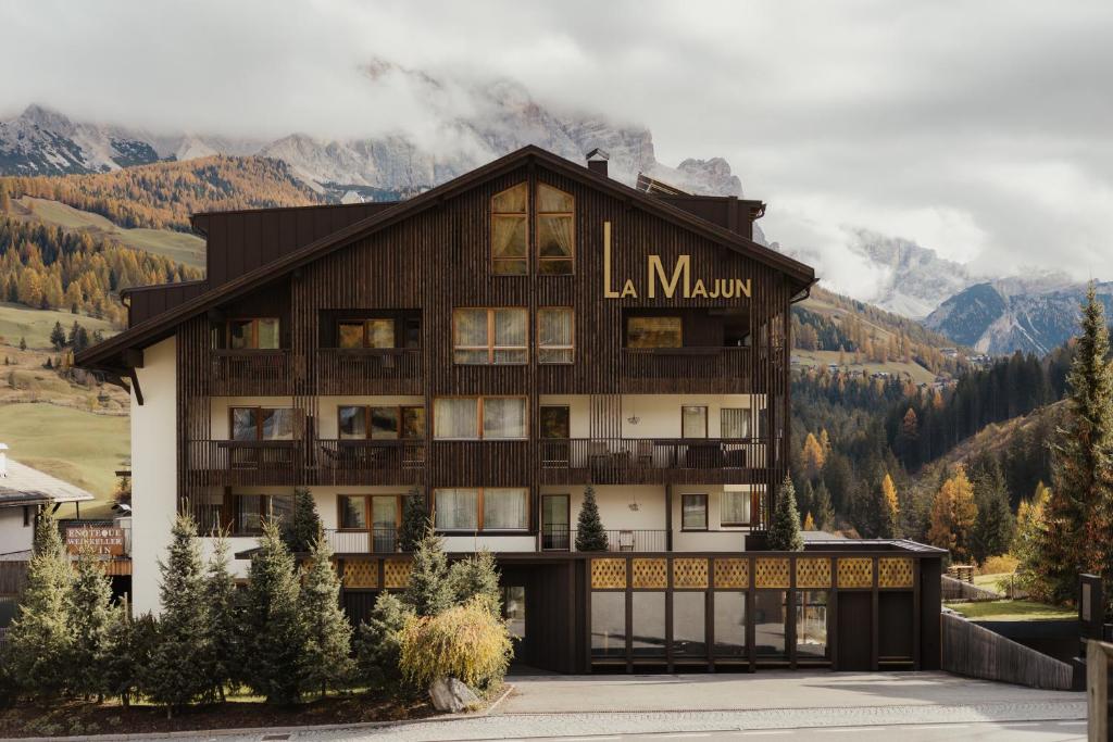 a large building with mountains in the background at Hotel La Majun in La Villa